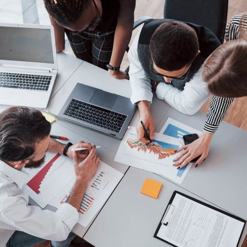 Imagen ilustrativa del servicio de productividad: Empleados trabajando en equipo en una mesa de trabajo.